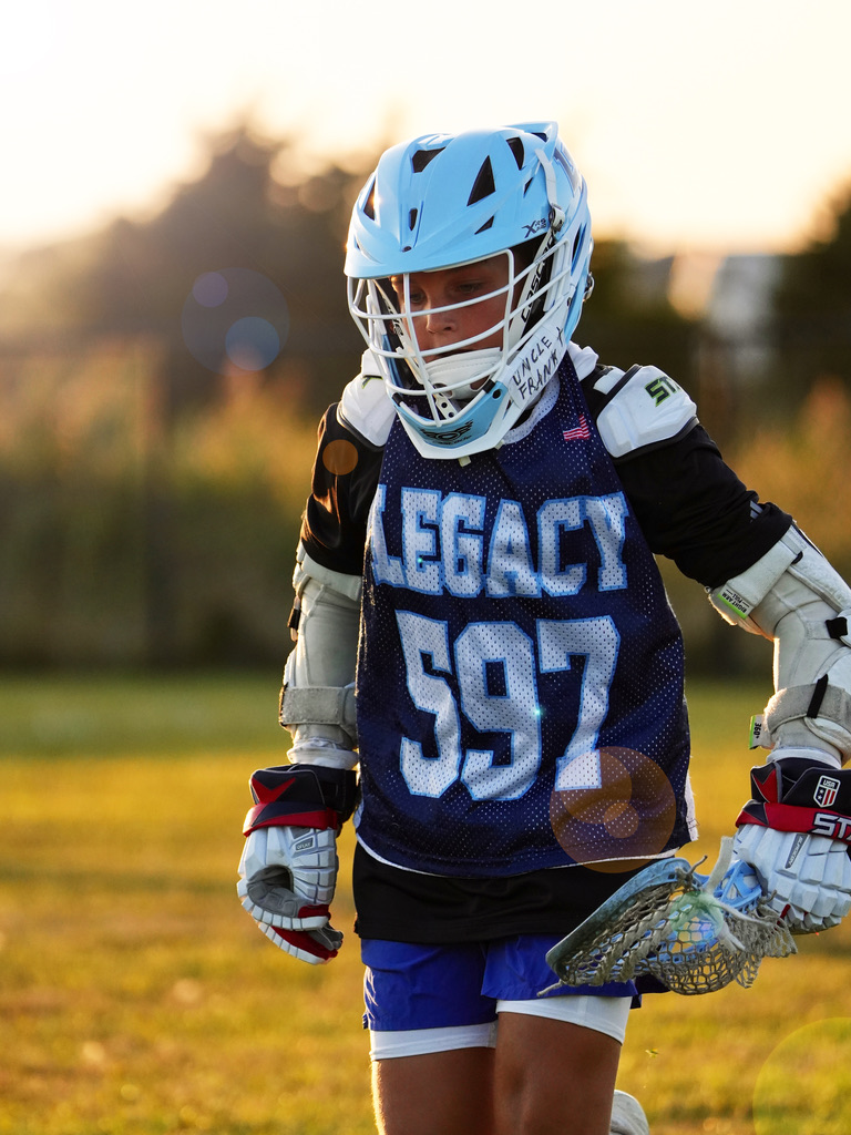 Youth lacrosse player photographed at golden hour